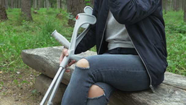 障害のある女性と松葉杖とベンチでコーヒーを取ります - 映像、動画