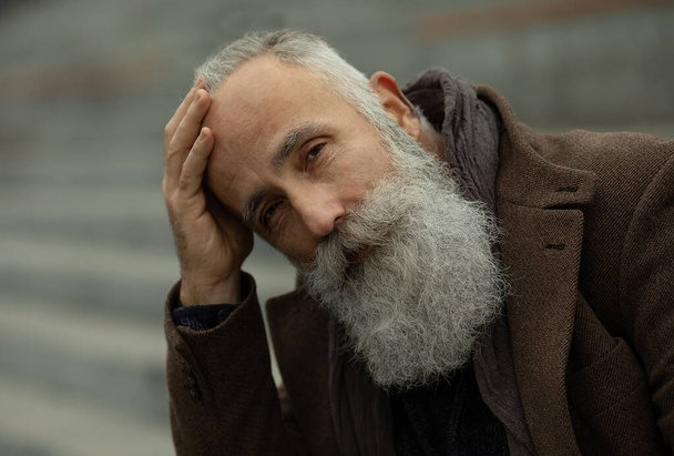 Portrait of handsome mature man, outdoors. Old man with a grey beard. Fashion look. - 写真・画像