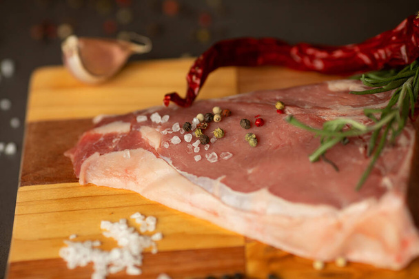 Steak raw. Barbecue Rib Eye Steak or rump steak on rustic table with rosemary. T-Bone steak. - Photo, image