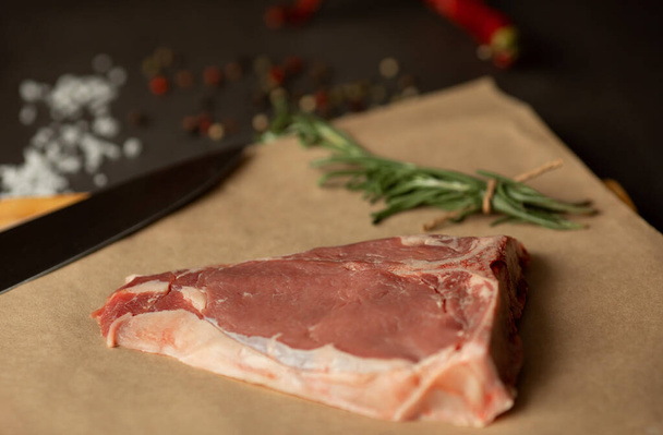 Steak raw. Barbecue Rib Eye Steak or rump steak on rustic table with rosemary. T-Bone steak. - Zdjęcie, obraz