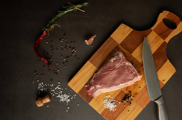 Steak raw. Barbecue Rib Eye Steak or rump steak on rustic table with rosemary. T-Bone steak. - Photo, image