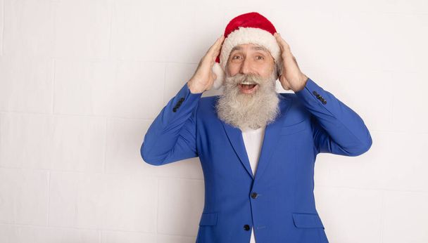 Holly jolly xmas, new year is soon! Be ready, prepare. Sales, discounts, presents, gifts selling time. Man wearing blue suit and red hat. - Φωτογραφία, εικόνα