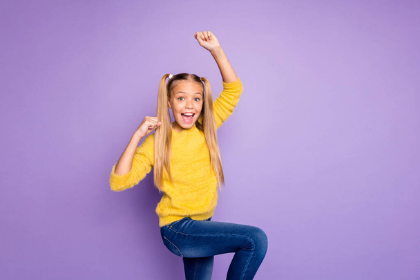 Photo of cheerful positive excited girl wearing yellow sweater jeans denim with astonishment on face screaming isolated pastel color violet background - Fotografie, Obrázek