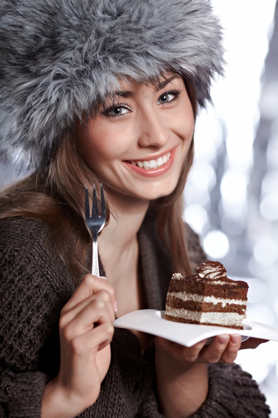 beautiful winter woman eating cake - Fotoğraf, Görsel