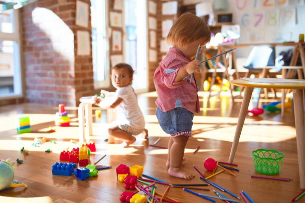 Adorables tout-petits jouant autour de beaucoup de jouets à la maternelle
 - Photo, image