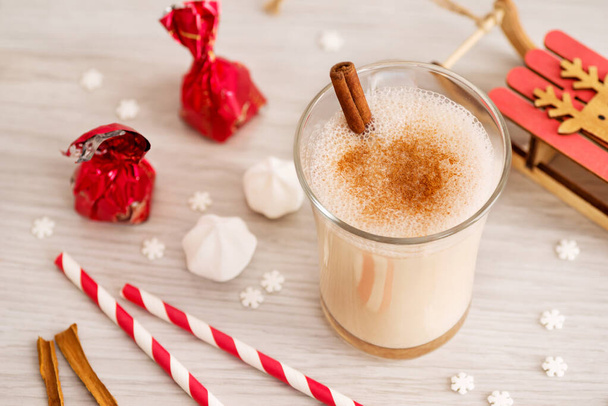 Eggnog in glass cups with a delicate foam, spices and a cinnamon stick - Φωτογραφία, εικόνα
