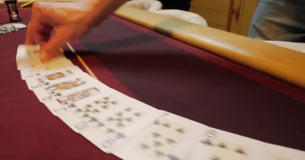 Kasino: Dealer muž míchá pokerové karty a provádění trik s kartami. - Záběry, video