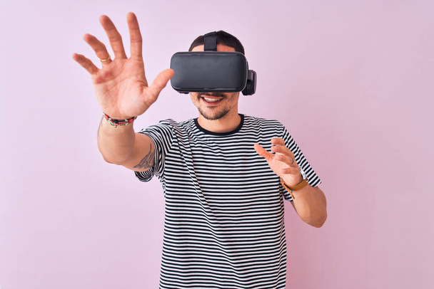 Nuori mies pelaa videopeli yllään virtuaalitodellisuus lasit, katsot virtuaalinen simulointi hämmästynyt ja hymyillen onnellinen
 - Valokuva, kuva