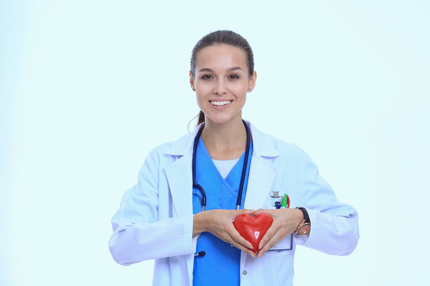 Beautiful smiling female doctor holding red heart and green apple. Woman doctor - Фото, изображение