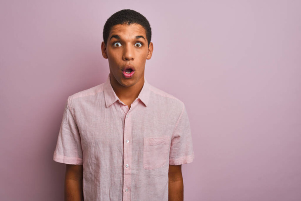 Young handsome arab man wearing casual shirt standing over isolated pink background afraid and shocked with surprise expression, fear and excited face. - Photo, Image