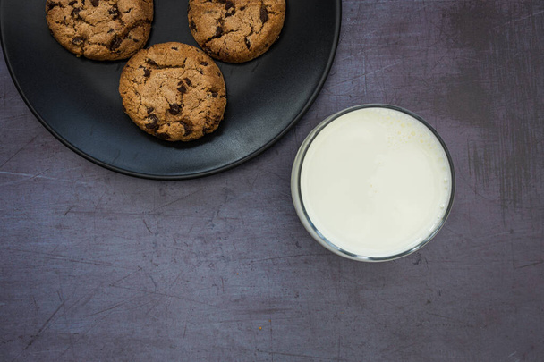 Melk koekjes koekjes chocolade chip bovenaanzicht donkere achtergrond - Foto, afbeelding