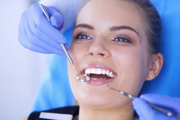 Fiatal nő nyitott szájjal fogászati vizsgálatot végez a fogorvosi rendelőben. - Fotó, kép