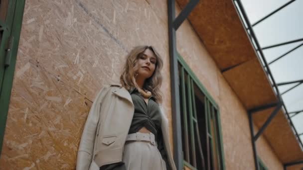 Mujer de moda apoyada en la pared de establo
 - Metraje, vídeo