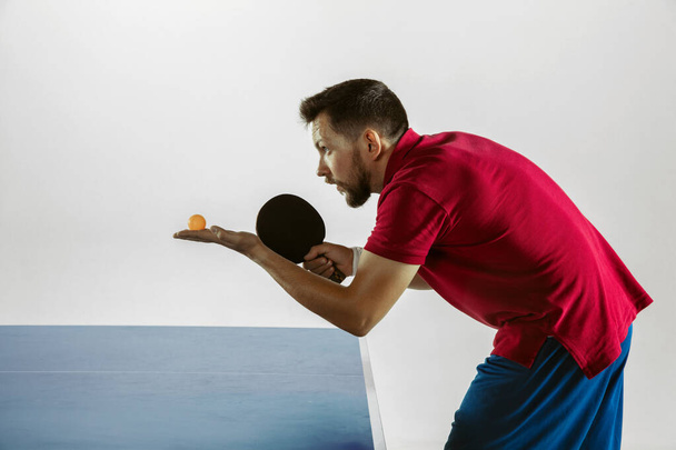 Young man playing table tennis on white studio background - 写真・画像