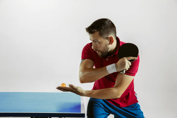 Young man playing table tennis on white studio background - Photo, Image