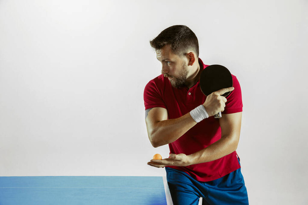 Young man playing table tennis on white studio background - Photo, Image