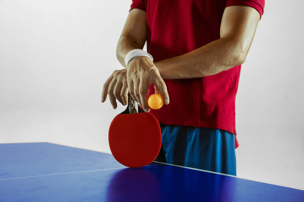 Young man playing table tennis on white studio background - Photo, image