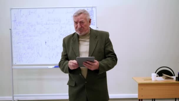 Happy professor met tablet geeft een lezing. - Video