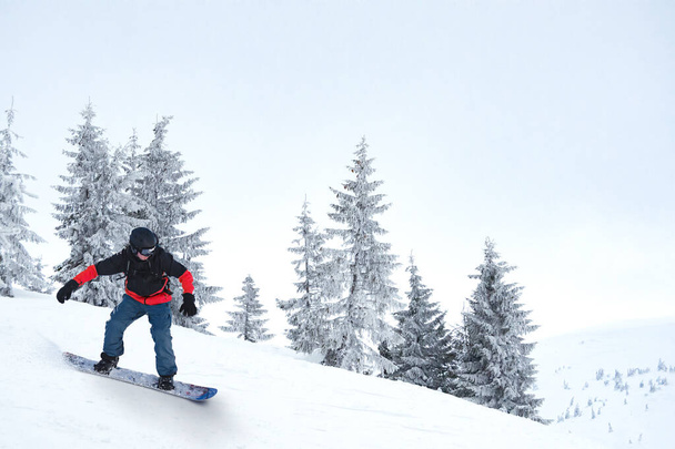 Snowboarder Riding Snowboard in Mountains. Snowboarding and Winter Sports - Foto, Imagem