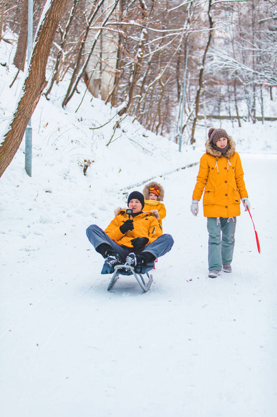giovane famiglia che si riunisce all'aperto in una giornata invernale nevosa
 - Foto, immagini