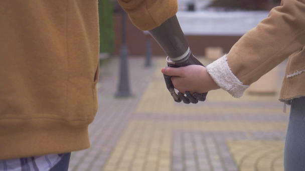 junger Mann mit Cyber-Prothese hält die Hand seiner Geliebten - Filmmaterial, Video