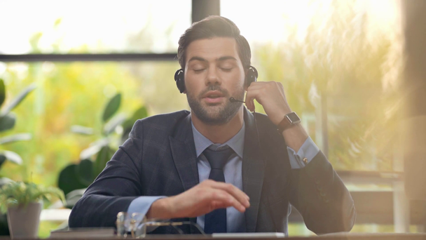 handsome operator in headset talking in office  - Кадри, відео