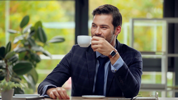 wybiórczy nacisk na biznesmena pijącego kawę w biurze  - Materiał filmowy, wideo
