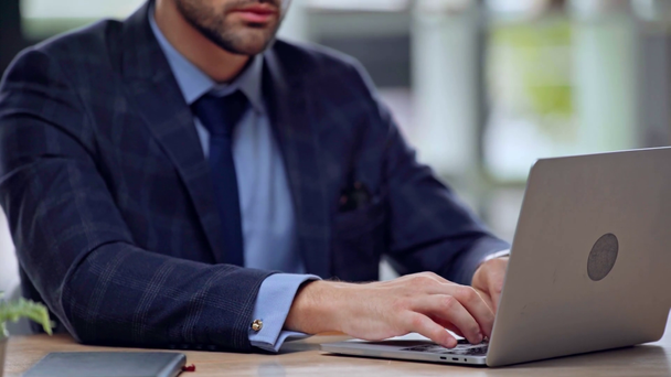 vista recortada de hombre de negocios escribiendo en el ordenador portátil
  - Metraje, vídeo
