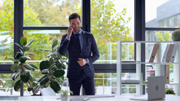 liikemies puhuu älypuhelimella ja kävelee toimistossa
  - Materiaali, video