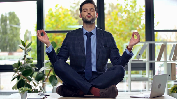 Hombre de negocios guapo meditando en la oficina
  - Imágenes, Vídeo