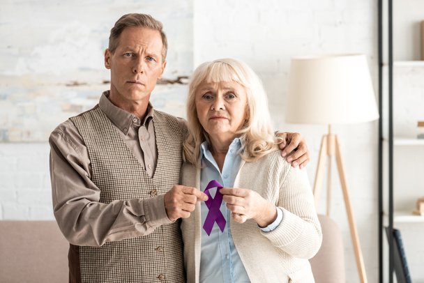 senior couple debout et tenant un ruban violet
  - Photo, image