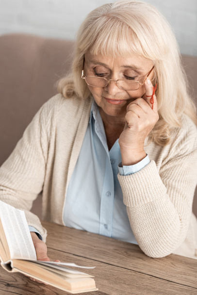 mulher sênior com alzheimers doença corda dedo humano lembrete leitura livro ao tocar óculos
  - Foto, Imagem
