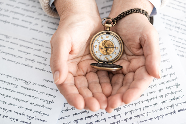 top view of senior woman holding pocket watch near papers with letters  - Photo, Image