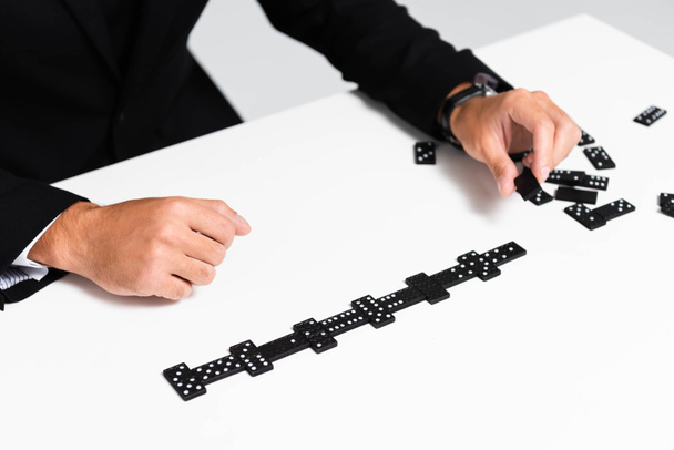cropped view of businessman in suit playing domino  - Photo, image