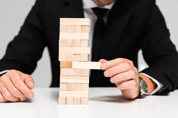 cropped view of businessman in suit playing blocks wood game isolated on grey  - Фото, зображення