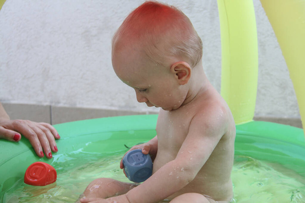 schöner einjähriger Junge spielt im Schwimmbad - Foto, Bild