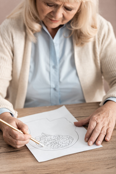 selective focus of sick senior woman drawing on paper  - Photo, Image