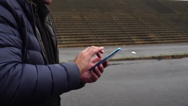 Mani maschili digitando su uno smartphone mobile, all'aperto
 - Filmati, video