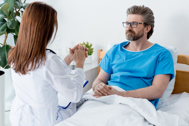 visszapillantás orvos fehér köpenyben beszél beteg a kórházban  - Fotó, kép