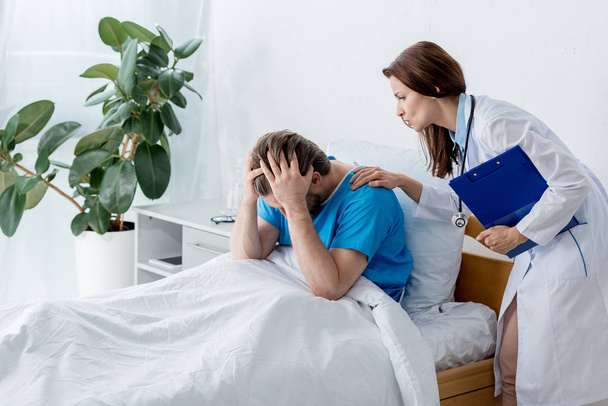 doctor in white coat calming down upset patient in hospital  - Foto, afbeelding