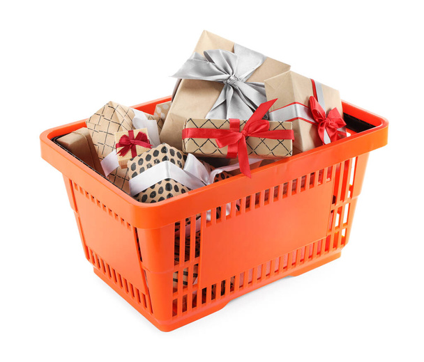 Orange shopping basket with different gifts on white background - Fotoğraf, Görsel