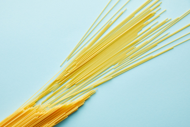 top view of raw spaghetti on blue background with copy space - Photo, Image