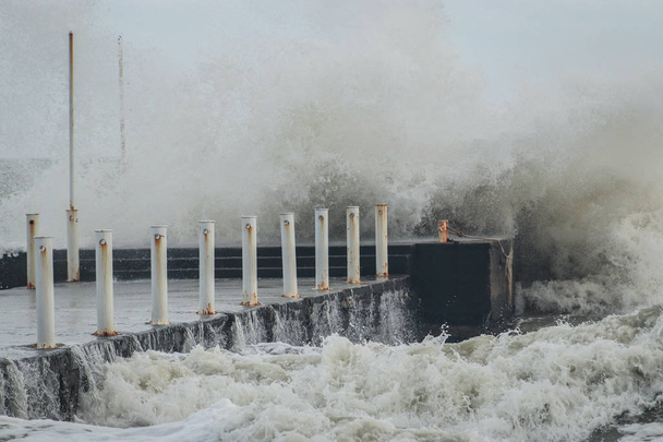 Wellenbrecher und Hafen bei stürmischem Wetter mit riesigen Wellen, die über die Mauern der Seebrücke krachen. ungewöhnlich starke Stürme in den mittleren Breiten infolge der globalen Erwärmung. - Foto, Bild