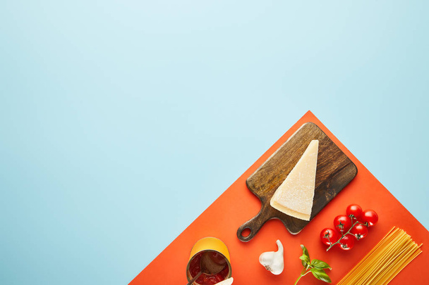 lapos laikus finom tészta paradicsommártással összetevők kék, piros háttér - Fotó, kép
