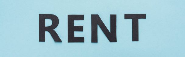 top view of paper cut black rent lettering on blue background, panoramic shot - Foto, Bild