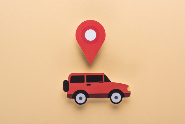 top view of paper cut car and location mark on beige background, car rent concept - Photo, Image