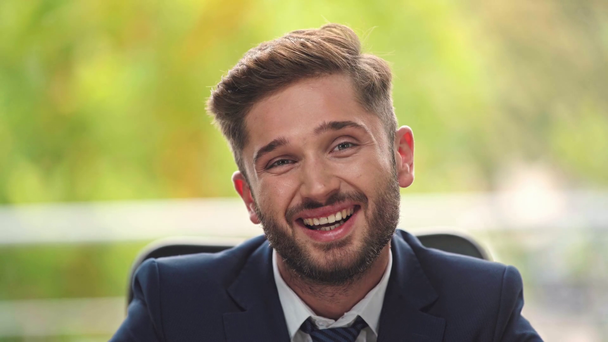 fiatal üzletember mosolyog, miközben a kamerába néz - Felvétel, videó