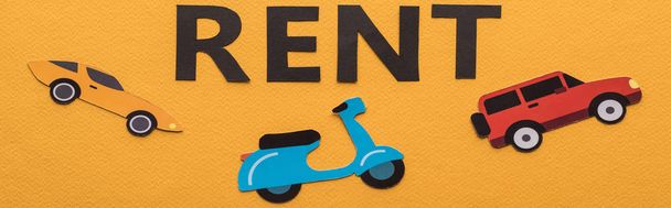 top view of paper cut vehicles and black rent lettering on orange background, panoramic shot - Photo, Image