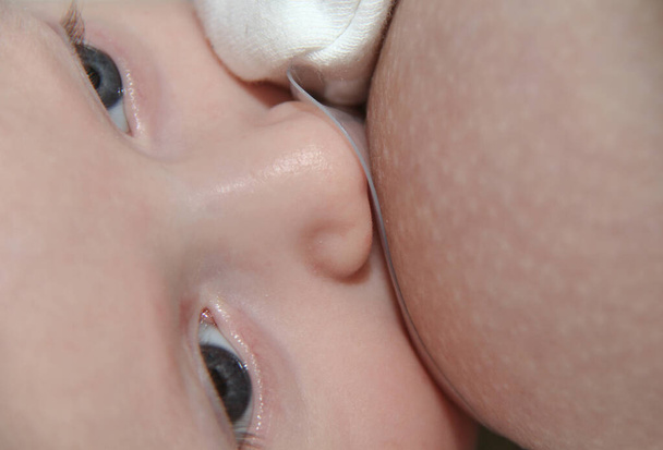 Jovem mãe amamentando seu bebê menino
 - Foto, Imagem