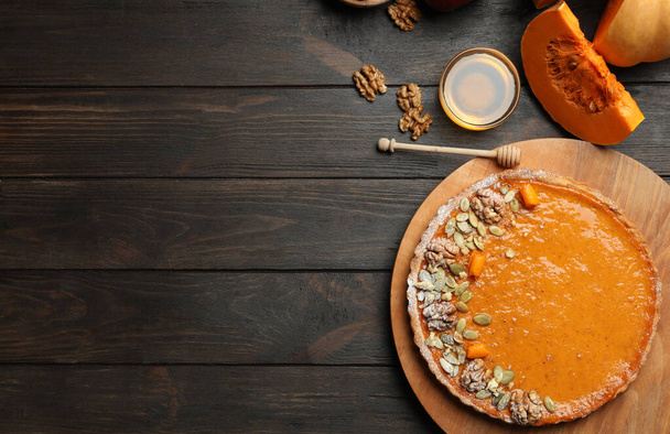 Flat lay composition with delicious fresh homemade pumpkin pie on dark wooden table. Space for text - Foto, immagini